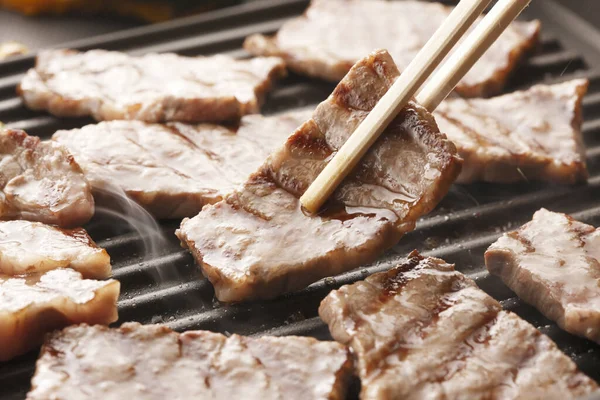 用筷子把肉放在烤架上 烤肉很好吃 — 图库照片