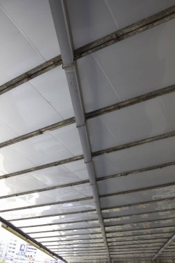 Açık havada şeffaf çatı yapısını destekleyen metal kirişler.