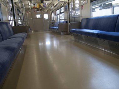 Trenin içi boş, mavi koltuklar ve temiz zemin görünüyor.