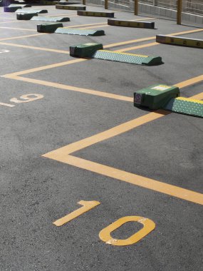 Boş otopark numaralandırılmış alanlar ve yeşil engeller gösteriyor