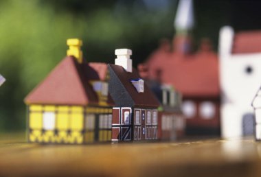 Ahşap yüzeyde, geçmişi bulanık minyatür evler.