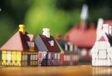 Tahta yüzey üzerinde minyatür renkli evler.