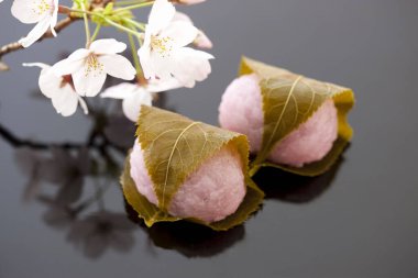 Yumuşak Asya tatlıları. Yeşil yapraklara sarılmış Japon Mochi. 