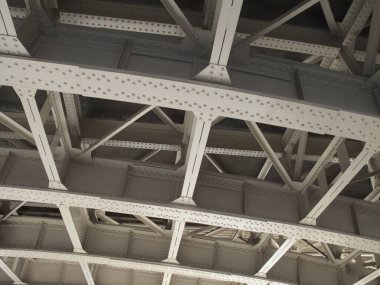 Karmaşık metal kirişlere ve desteklere bakıyorum.