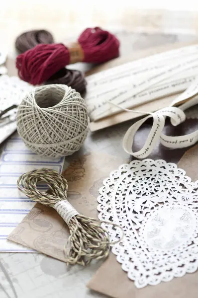 Ahşap yüzeyde çeşitli iplikler ve kurdeleler sıralanmış.