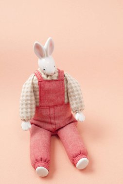 Pembe arka planda el yapımı oyuncak tavşan.