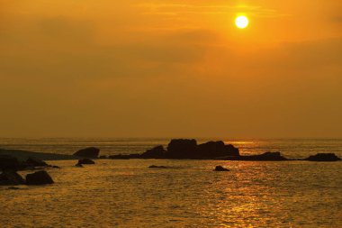 Sahilde gün batımı. Arka planda güzel bir gökyüzü.