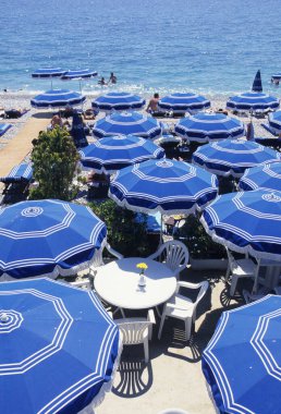 Güzel deniz kıyısında plaj şemsiyeleri ve sandalyeler.