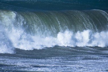 Denizdeki dalgaların gündüz görüntüsü. Denizin üzerindeki mavi gökyüzü