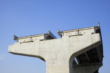 Otoyol inşaatı, mavi gökyüzüne karşı beton köprü desteği