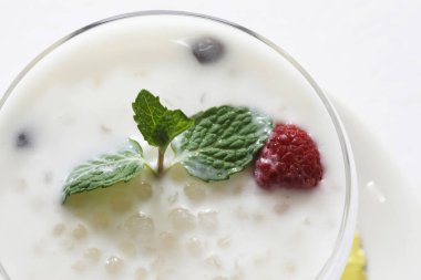 Taze sağlıklı içeceğe yakın çekim, bardakta meyveler.