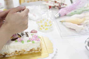 Pastayı renkli şekerleme çiçekleriyle süslüyorum.