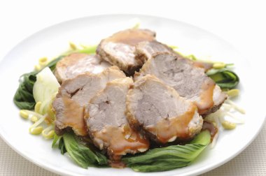 Dilimlenmiş et buğulanmış yeşil sebze tabağında dinleniyor.