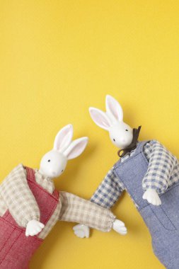 Sarı arka planda iki yumuşak el yapımı tavşan. 
