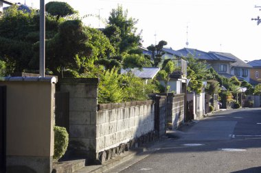 Kesilmiş çitleri ve beton duvarları olan sessiz bir yerleşim yeri.