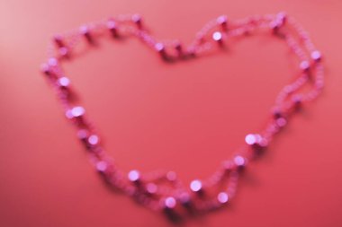 Pembe boncuklar kalp şeklini oluşturuyor.