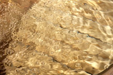 Altın bir arka planda su damlaları, yakın çekim 