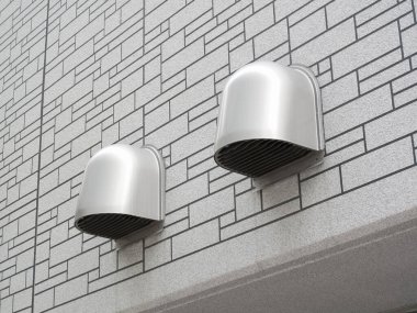 İki metalik havalandırma desenli dış duvar yüzeyinden dışarı çıkıyor.