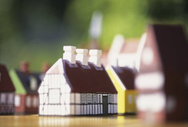 Tahta yüzeyde yakın sıralanmış minyatür evler.