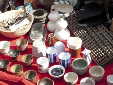 Seramik bardaklar ve kaseler açık havada sergileniyor.