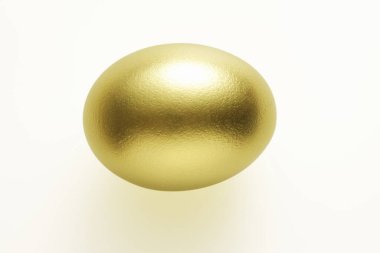  Beyaz arka planda altın yumurta, yakın plan.