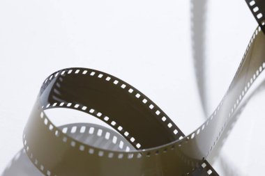 Beyaz arkaplanda film şeritlerinin yakın plan görüntüsü.         