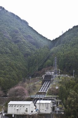 Yeşil ormanlı dağların arasına kurulmuş hidroelektrik santrali