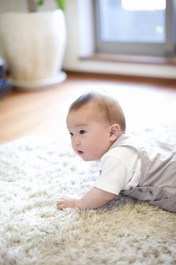 Evde yerde sürünen sevimli küçük Japon çocuk.