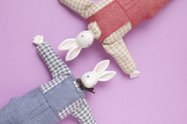 Mor arka planda iki yumuşak el yapımı tavşan. 