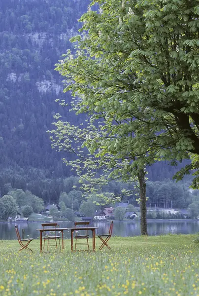 Dağlarda gölde sandalyeli masa manzarası