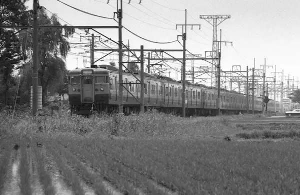 Tren raylar boyunca ilerliyor. siyah ve beyaz fotoğraf olay yerini yakalıyor.