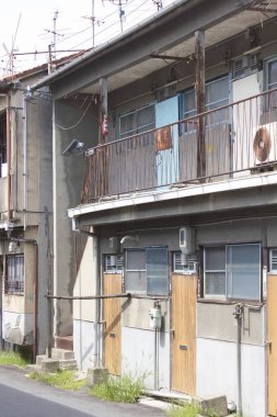 Paslı korkulukları ve soyulmuş boyaları gösteren yıpranmış bir apartman.