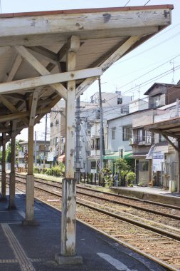 Şehir demiryolunun iyi bakımlı dış hatları yoğun bir Japon caddesine paraleldir..