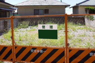 İkametgah evleri arasında otlar olan boş bir arazi bulundu.