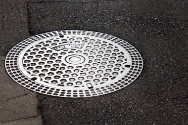  Kapak, Japonya 'da gri asfalt arka planda desenli, dökme demir grisidir.