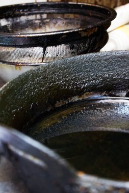 Yakın plan, yoğun yemek kullanımından sonra yağlı, karartılmış kızartma tavalarını gösteriyor.