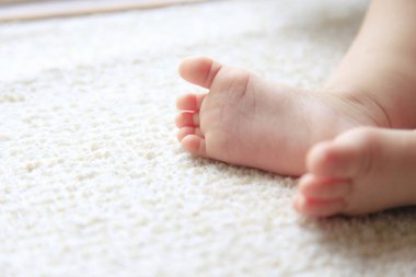 Halıdaki bebek bacakları. Yeni doğmuş küçük ayaklar.