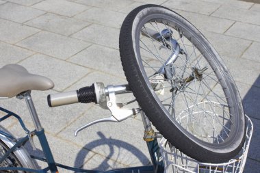 Bisiklet tekerlekleri ve metal sepet sokakta 