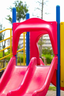 Parlak kırmızı plastik oyun alanı açık hava güneşli bir gün.