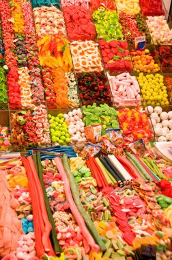 Değişik renkli şeker ve şekerlemelerle dolu market tezgahı