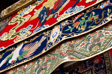 Renkli desenli halılar sarkıyor Karmaşık dokuma tasarımlar sergiliyor