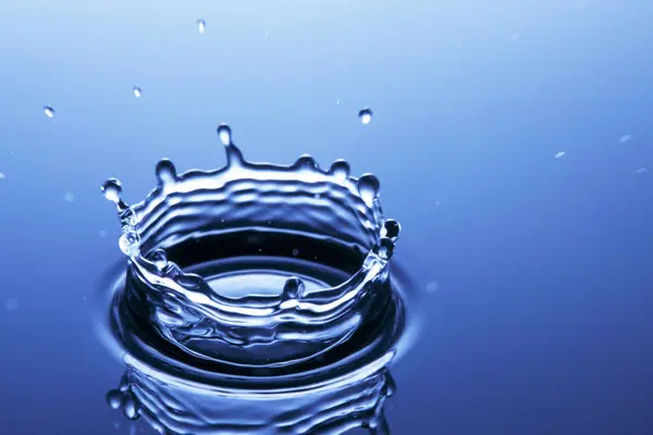 Respingo Água Sobre Fundo Azul — Fotografia de Stock