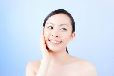 Genç ve güzel Asyalı kadın günlük cilt bakımını yapıyor.