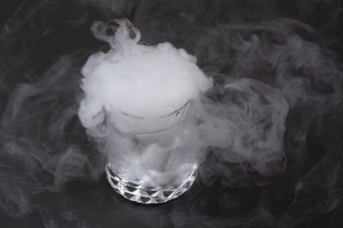 Koyu arkaplanda kuru buzun etkisi olan beyaz duman.