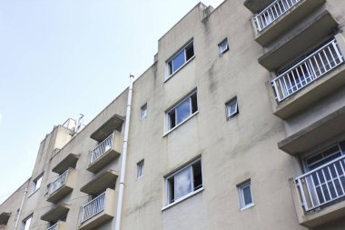 Dış bina gökyüzüne karşı birden fazla balkon ve pencere gösteriyor