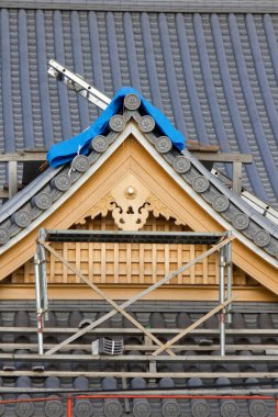 Tadilat sırasında geleneksel Japon çatısını çevreleyen iskeleler.