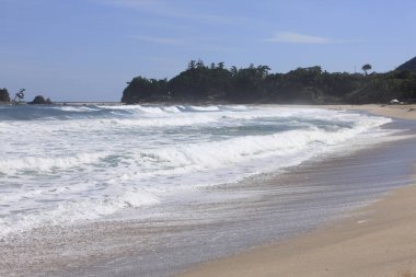 Sahile vuran köpüklü deniz dalgaları. 