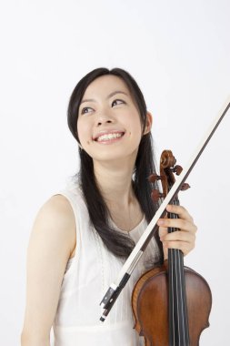 Beyaz arka planda keman çalan Asyalı kadın.