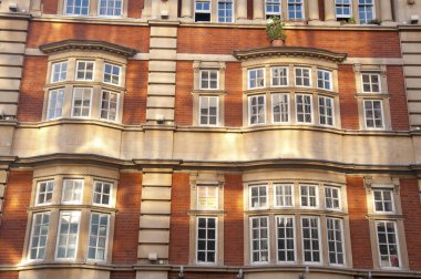 Güneş ışığı tarihi tuğla bina cephesi pencerelerine yansıyor