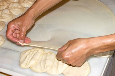 Mutfakta hamur tatlısı yapma süreci. Erkek eli hamurla çalışıyor.